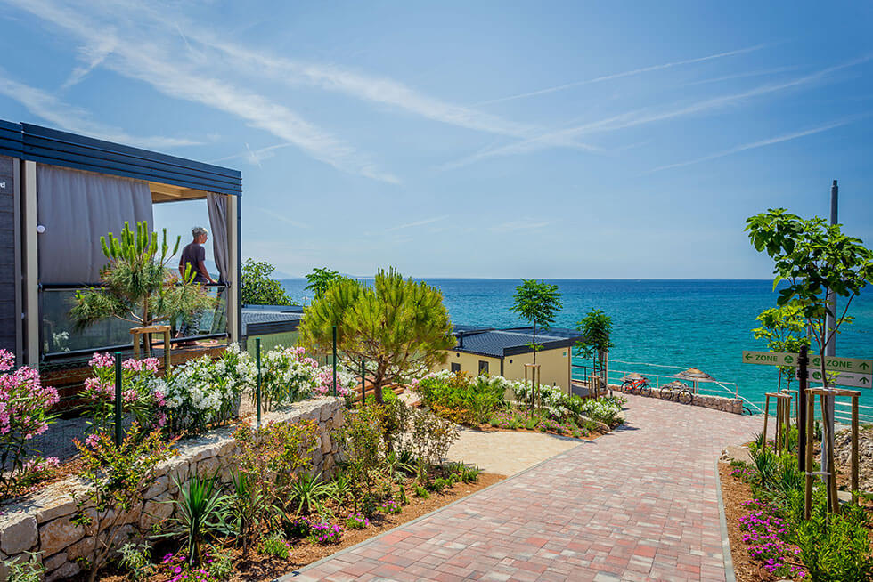 Seaside promenade at Valamar Camping Ježevac with modern mobile homes, landscaped greenery and Adriatic Sea view