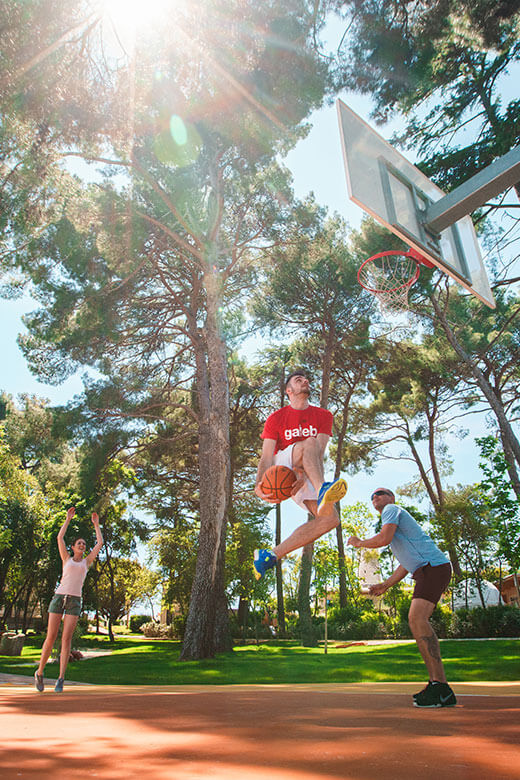 Ein Mann springt hoch in die Luft und spielt Basketball mit seiner Familie
