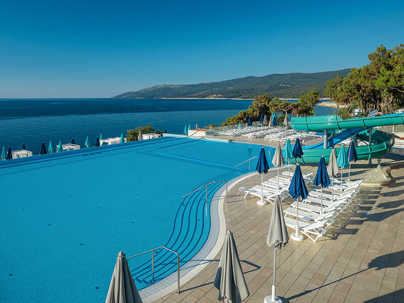 Sun loungers and umbrellas at the sea view Family pool in Girandella Family