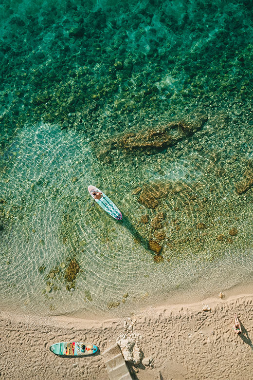 Pratiquant de paddle glissant sur les eaux cristallines de l’Adriatique sur une plage croate