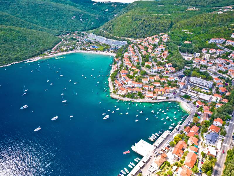 Obalni grad Rabac okružen zelenim brdima i plažama
