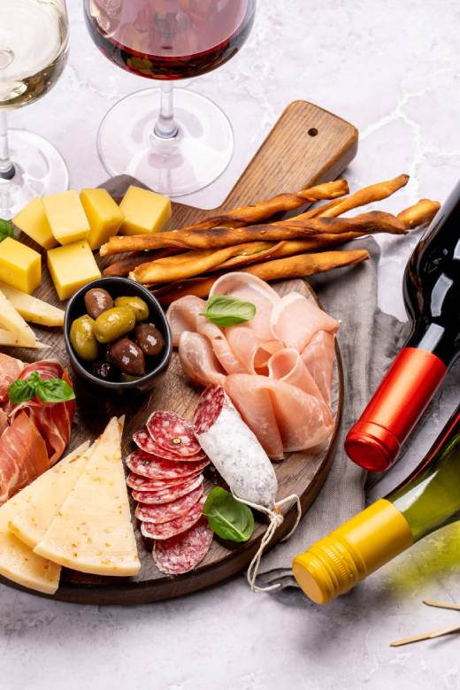 Plateau de charcuterie croate traditionnel avec fromage, olives et prosciutto servi avec du vin