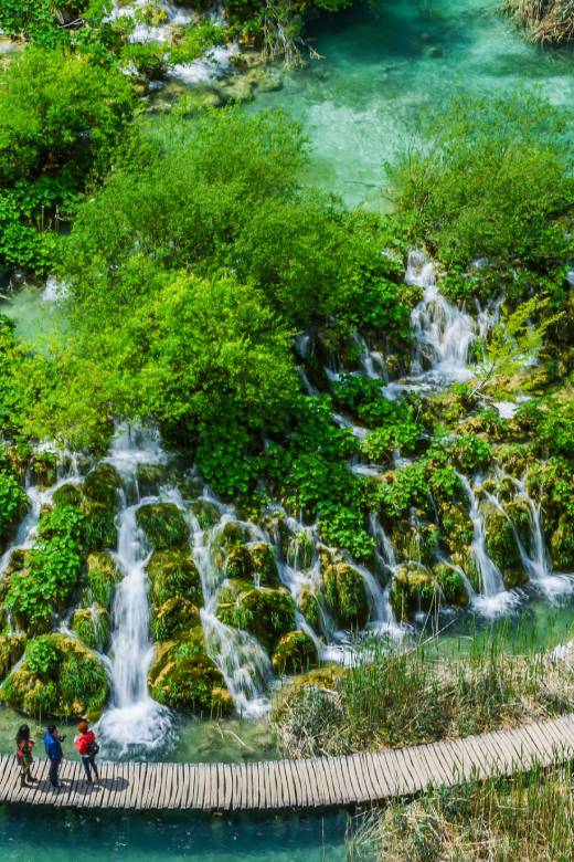 Visiteurs marchant sur des passerelles en bois près des cascades aux lacs de Plitvice, Croatie