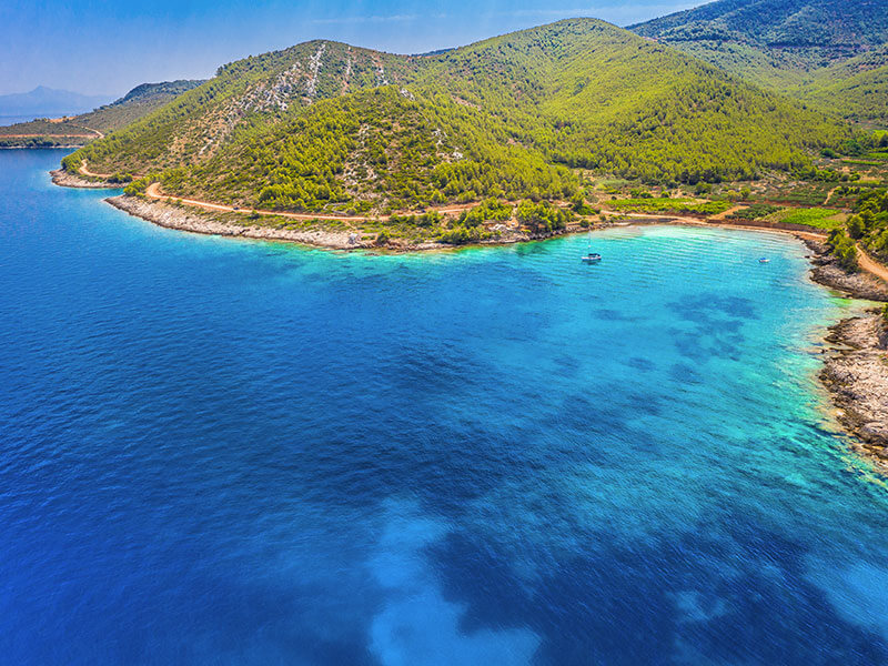 Turquoise bay and pine-covered hills on Hvar Island, Dalmatia.