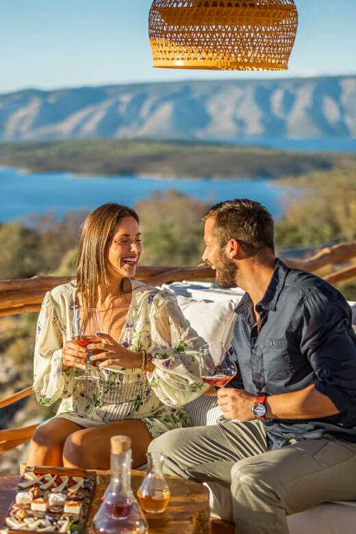 Deklica se nasmehne, medtem ko se rakovica Maro v ozadju igra z otroki.