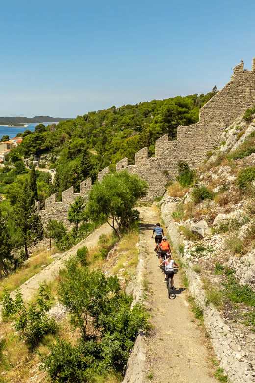 Deklica se nasmehne, medtem ko se rakovica Maro v ozadju igra z otroki.