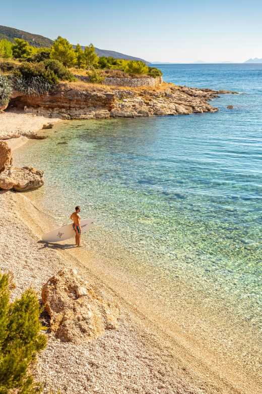 Deklica se nasmehne, medtem ko se rakovica Maro v ozadju igra z otroki.