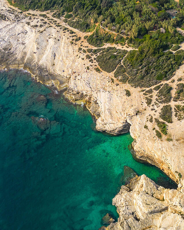 Côte croate escarpée avec végétation verte et mer bleue, idéale pour les randonneurs et les amoureux de la plage.