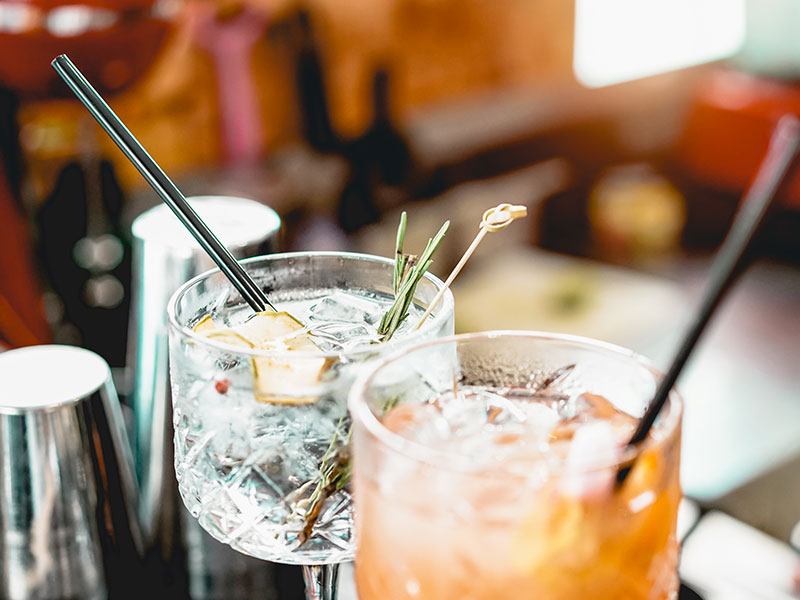 Barman představuje koktejl v tlumeně osvětleném baru