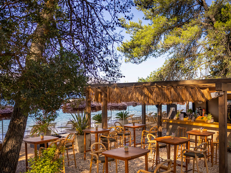 Priatelia si užívajú drinky pri západe slnka v Hula Hula Beach Bare na Hvare