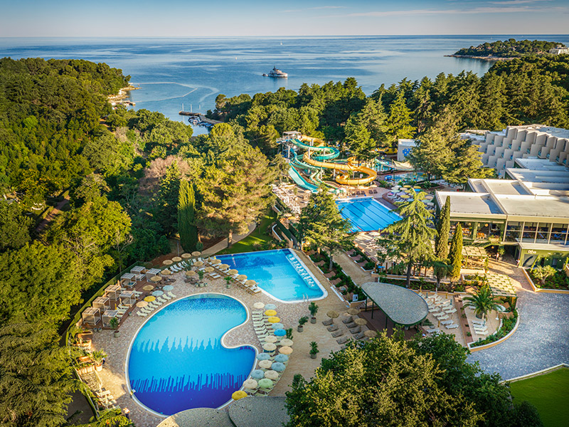 Vue aérienne des piscines extérieures entourées de verdure au Valamar Diamant Hotel à Poreč.