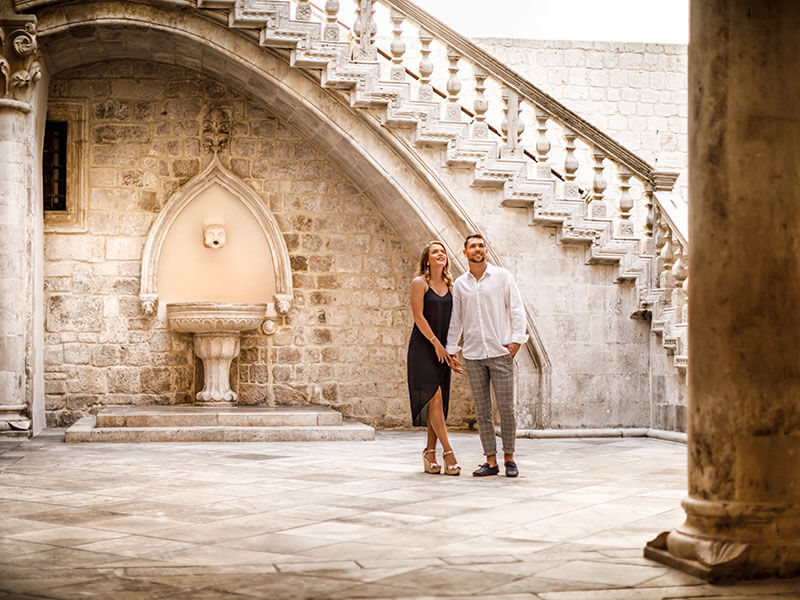 Tourist walking under stone arch at Rector’s Palace in Dubrovnik