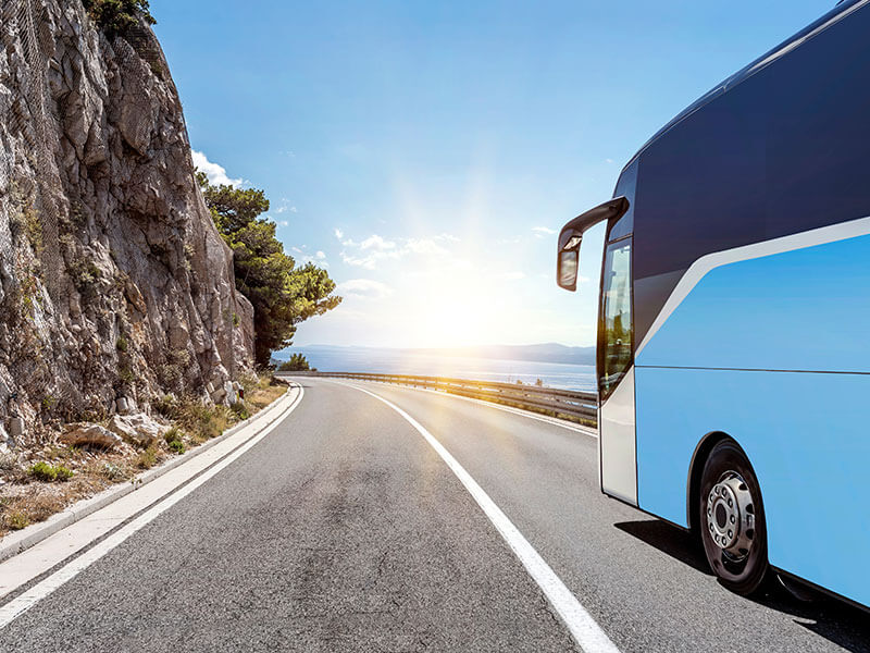 Reisebus fährt auf malerischer Küstenstraße