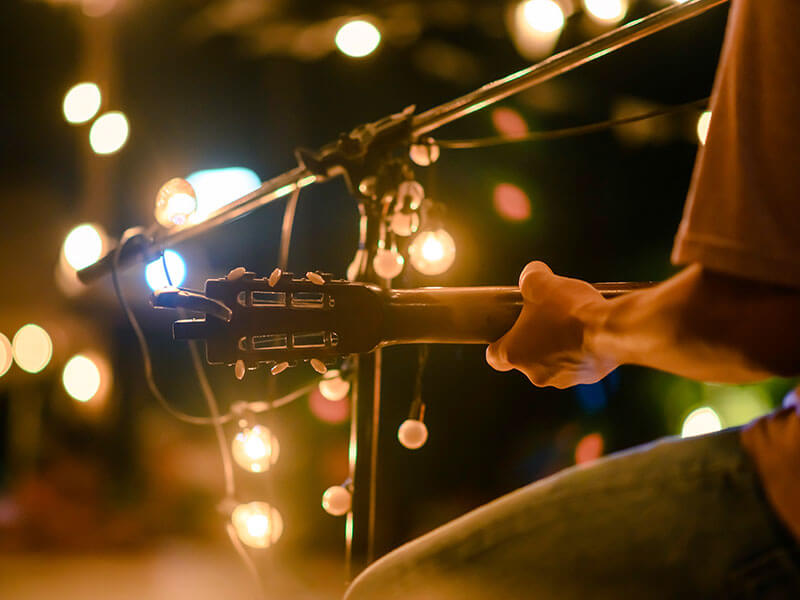 Guitar performance at a nighttime event with warm lighting