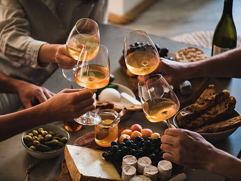 Freunde stoßen mit Weißwein in der Škar Winery & Wine Bar an