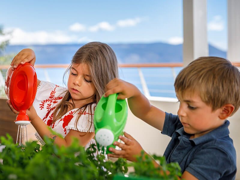 Un petit garçon et une fille arrosent des plantes