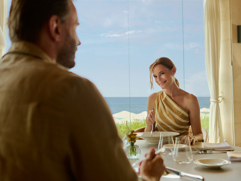 Coppia che gusta alta cucina con vista mare in un ristorante croato.