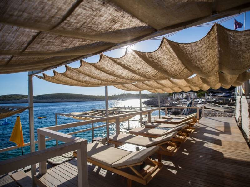 Ležaljke uz more pod baldahinima na plaži Carpe Diem