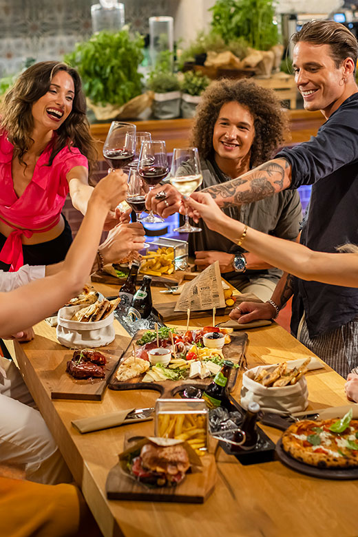 Freunde genießen ein lebendiges Abendessen mit lokalem Essen und Wein auf der Insel Hvar