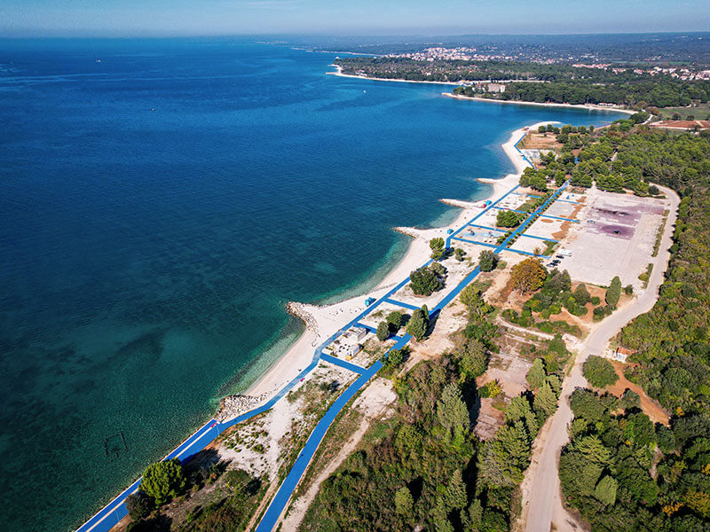Obmorska promenada in prodnata plaža v Hidrobazi blizu Pule