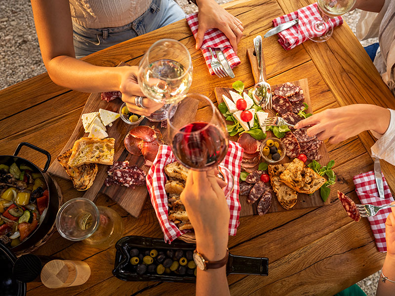 Shared charcuterie platter with wine at outdoor table