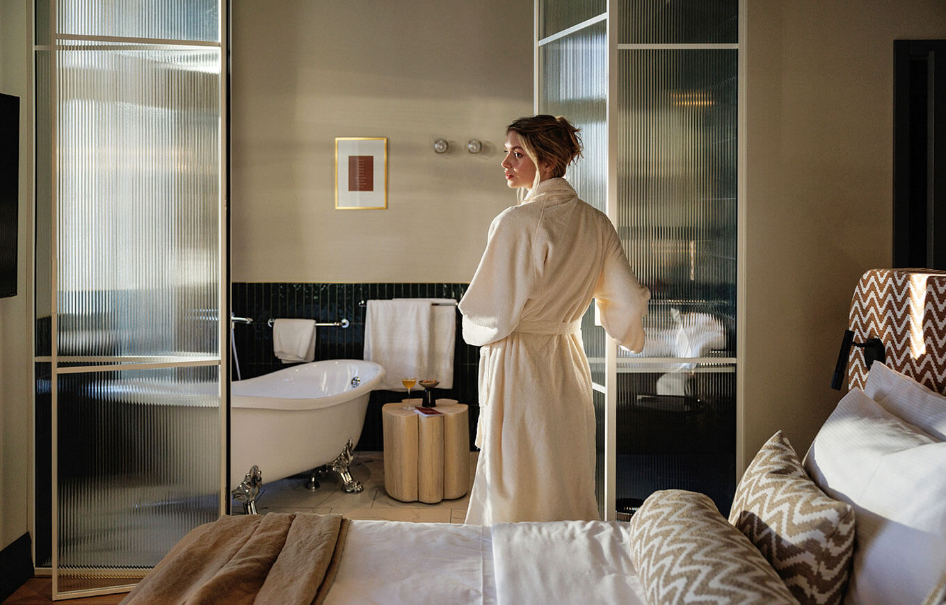 Kobieta w eleganckim szlafroku w pokoju dla 2 z widokiem na morze w Jadran Heritage Hotel