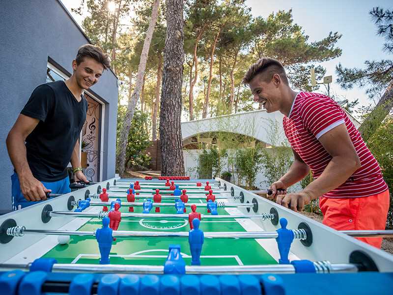 Bambini che corrono e giocano nel parco acquatico per bambini, pieno di spruzzatori e scivoli d'acqua.