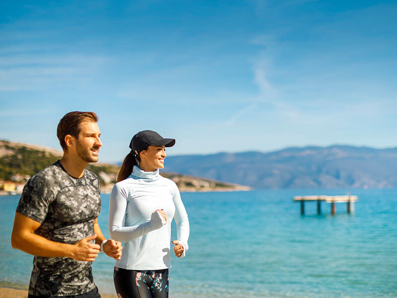 Coppia che fa jogging su un sentiero costiero.