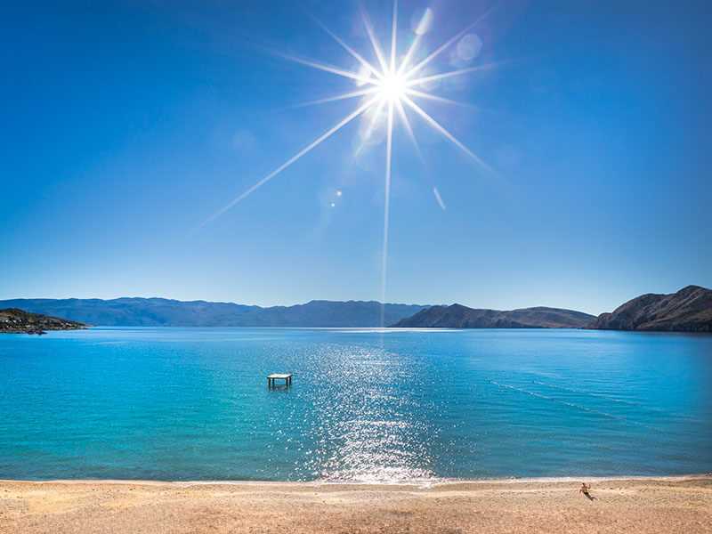 Plaža na otoku Krku s kristalno čistim morem i podnevnim suncem
