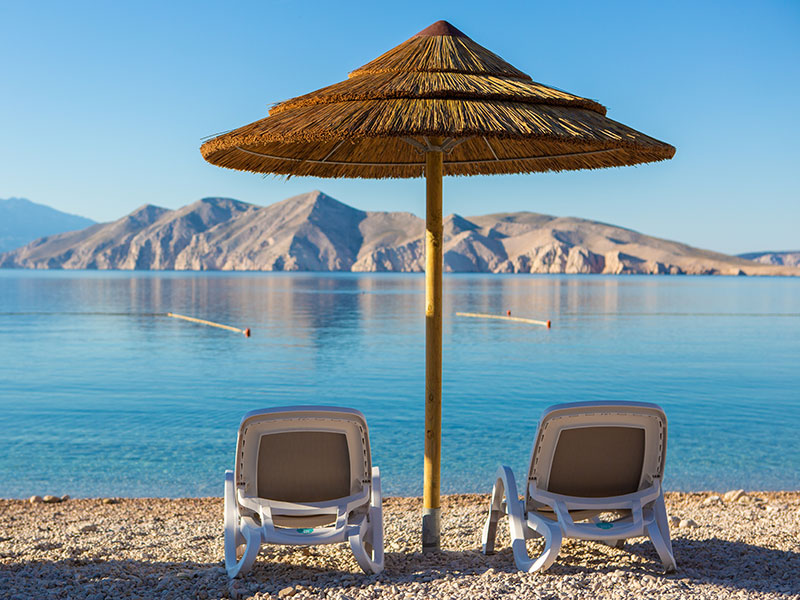 Ležaljke okrenute prema moru na plaži Dunat na Krku