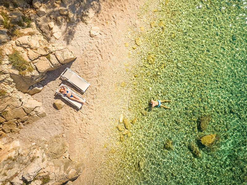 Nudistička plaža Redagara sa stjenovitom liticom i ležaljkama