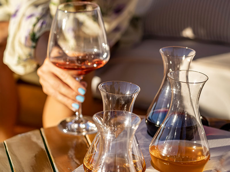 Mano che tiene un bicchiere di rosé durante una degustazione sull’isola di Krk