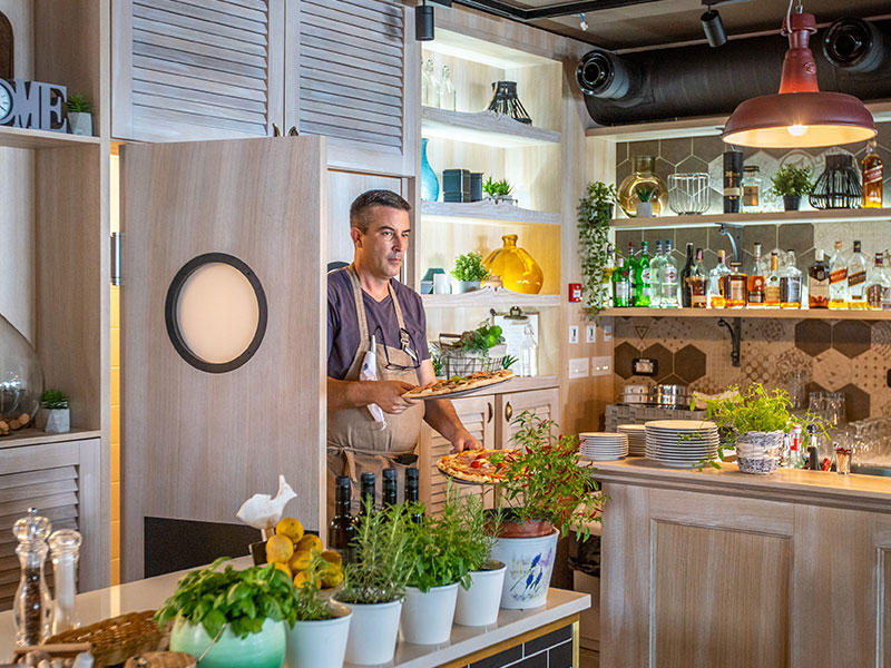 Chef in una trattoria italiana a Makarska con cucina sullo sfondo