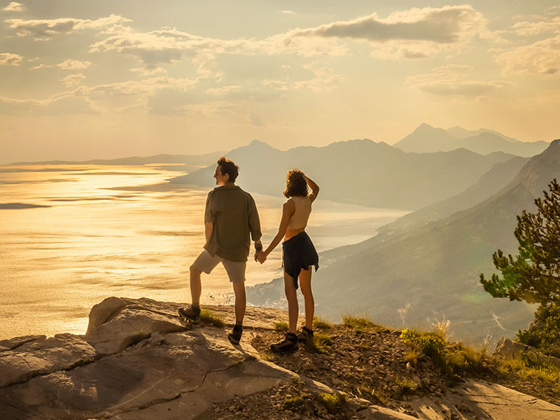 Couple enjoying sunset from Biokovo mountain viewpoint