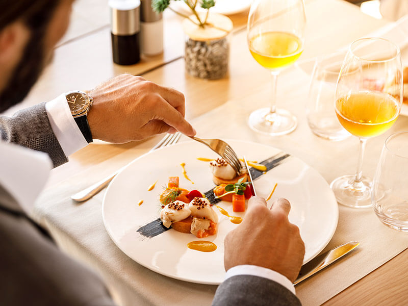 Frau isst Pasta und Bruschetti und trinkt Wein in einem Restaurant.