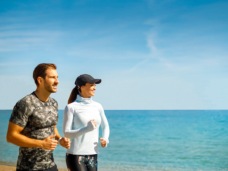 Coppia che fa jogging su un sentiero costiero.