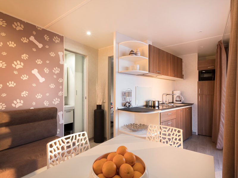 Pet-friendly Happy Dog Home za 4+2 osebi v Lanterna Camping Homes z moderno kuhinjo, jedilno mizo in steno z odtisi tačk – idealna mobilna hišica za goste s psi