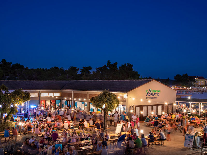 Večerni dogodek na Piazzi v Valamar Camping Istra z živo glasbo in gosti, ki večerjajo na prostem, le nekaj korakov od mobilnih hišic