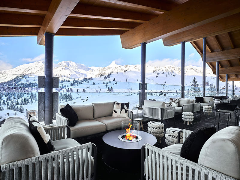 [PLACES ROOFTOP BAR] in Obertauern mit Panoramablick auf die verschneiten Alpen und einer stilvollen Après-Ski-Terrasse