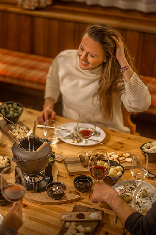 Skupina priateľov večeria a vychutnáva si fondue v reštaurácii Momenti