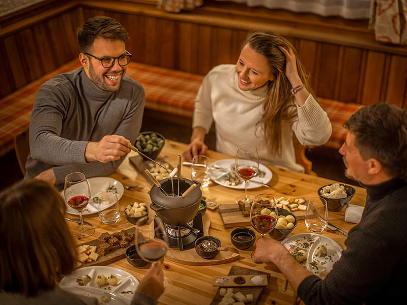 Eine Gruppe von Freunden beim Abendessen und Fondue im Restaurant Momenti