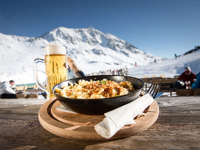 Traditionelle österreichische Küche und Bier mit Blick auf die Alpen