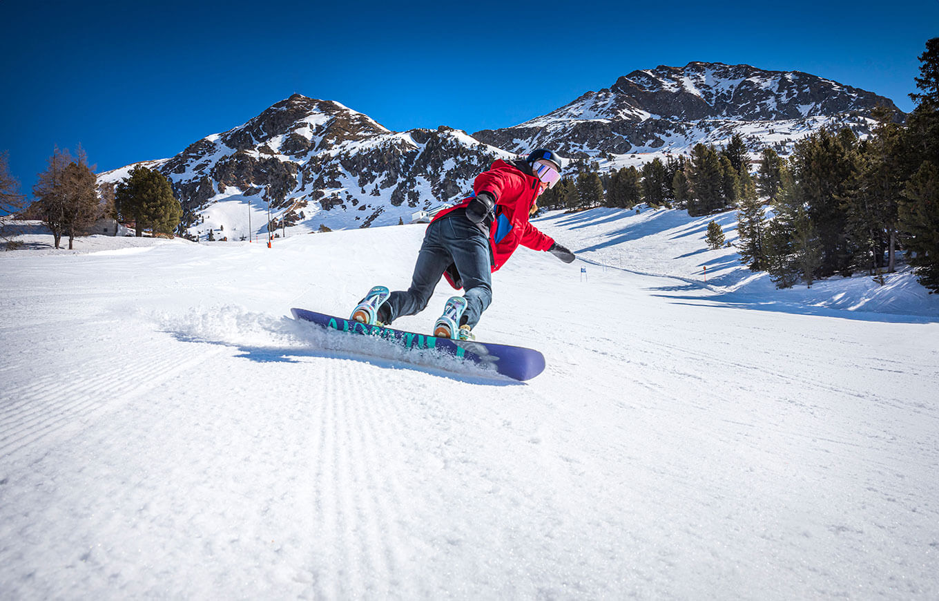 Osoba na snowboarde na zjazdovkách v Obertauernu