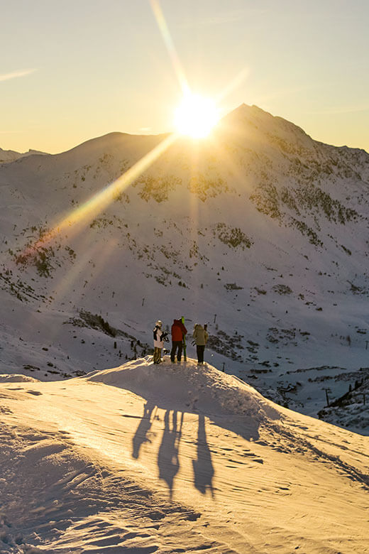 Slnko zapadá za vrcholom pohoria Radstädter Tauern v Rakúsku