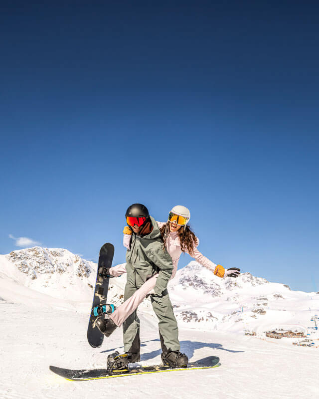 Snowboardisti si užívajú slnečný deň na zasnežených svahoch Obertauernu