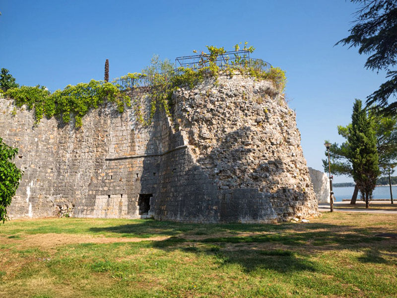 View of Poreč's historic towers surrounded by greenery