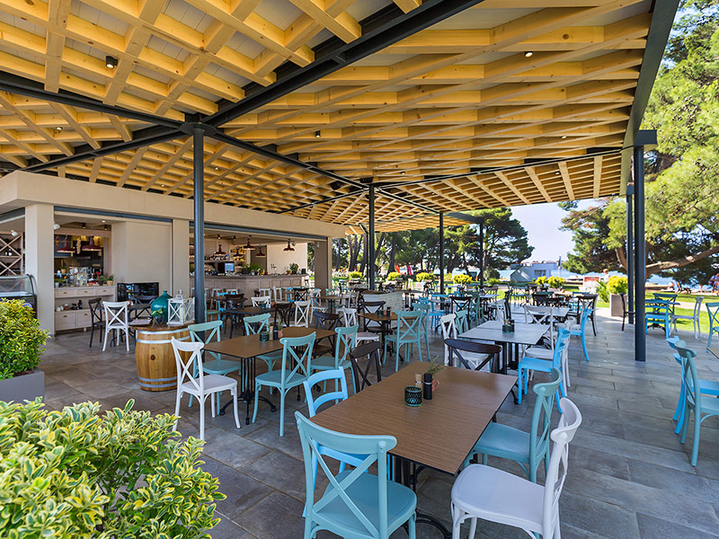 Outdoor dining area of Trattoria La Pentola with coastal views