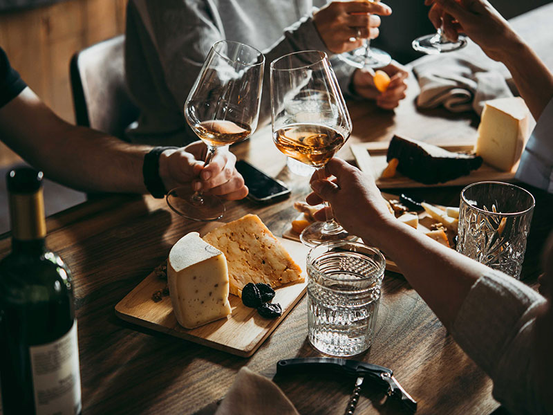Close-up of cheese platter and wine glasses during tasting