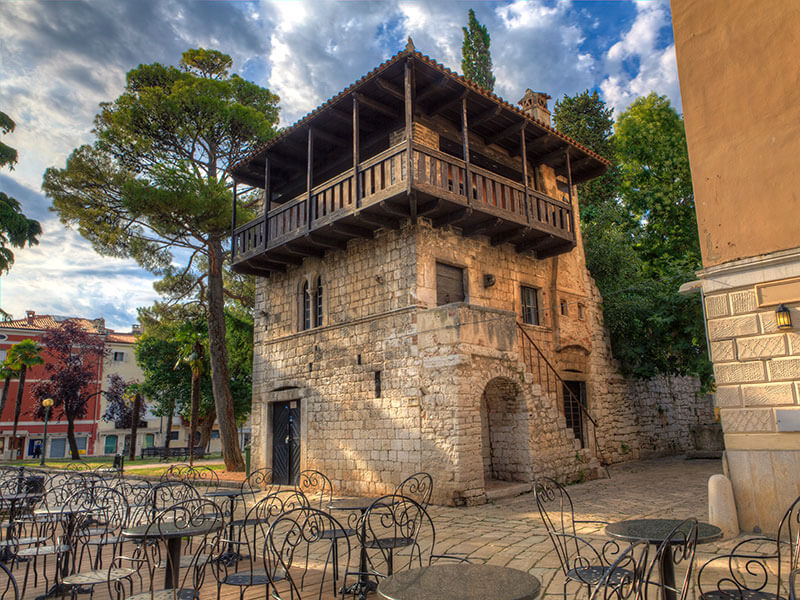 The Romanesque House in Poreč with stone façade and wooden balcony