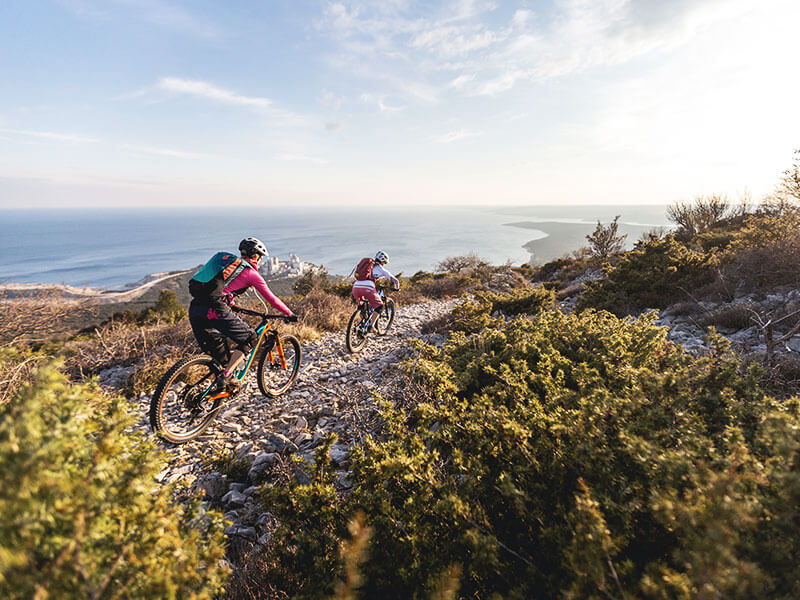Cyclists on a hilltop path along the St Michael trail with panoramic views